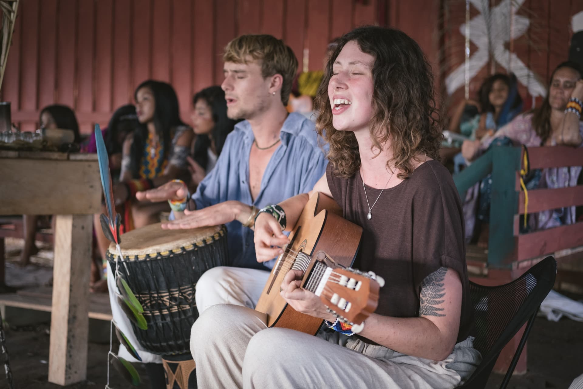 Genevieve and Milo singing together with guitar and djembe