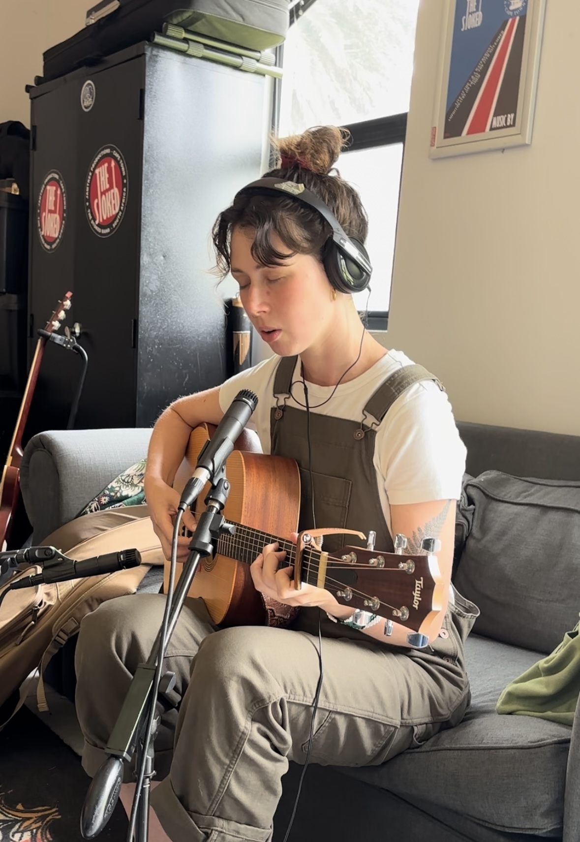 Genevieve recording an acoustic guitar take in headphones